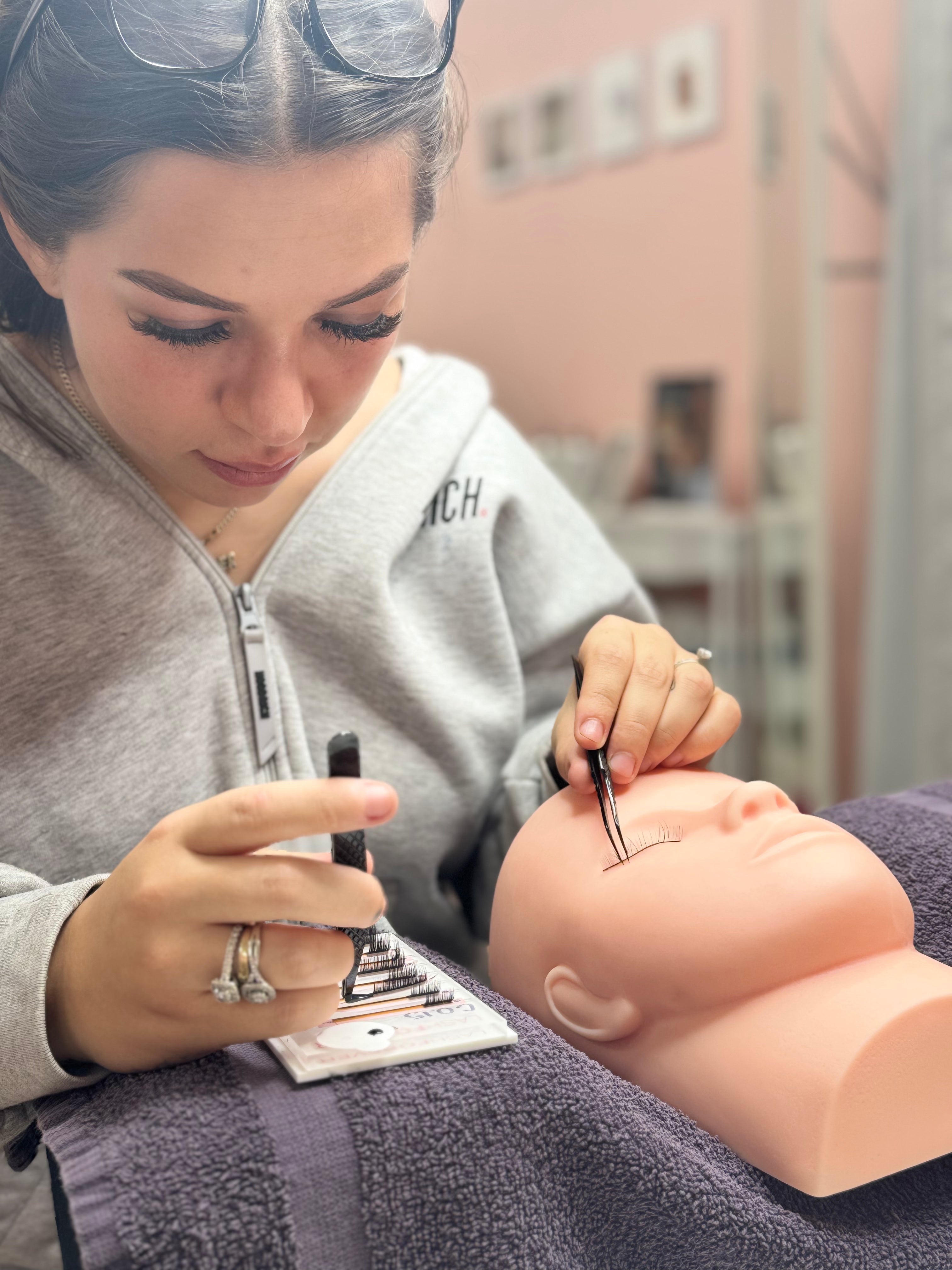Beginner lash artist working on a model to practice classic lash extensions