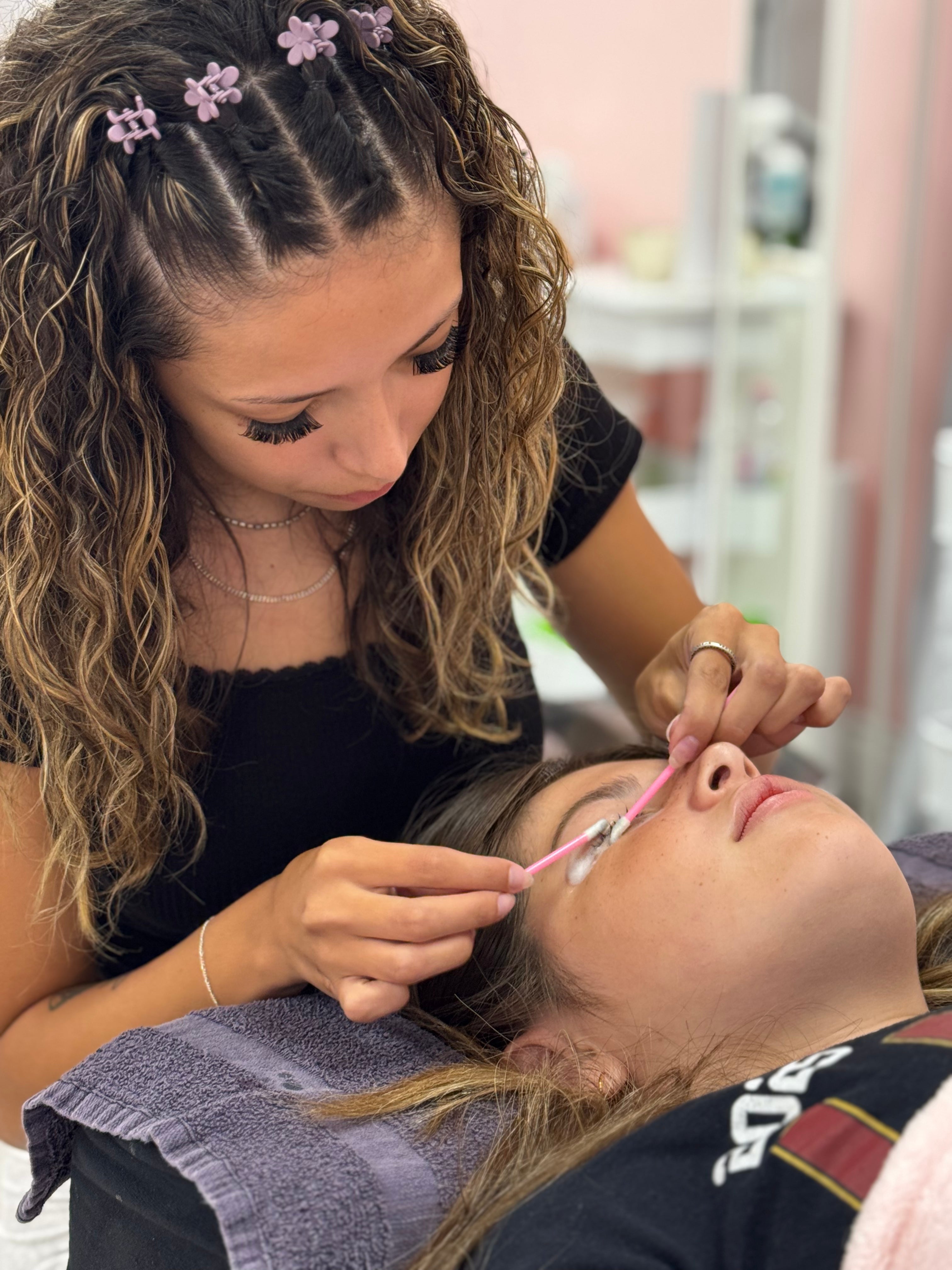 Aspiring lash artist practicing lash extensions during training course